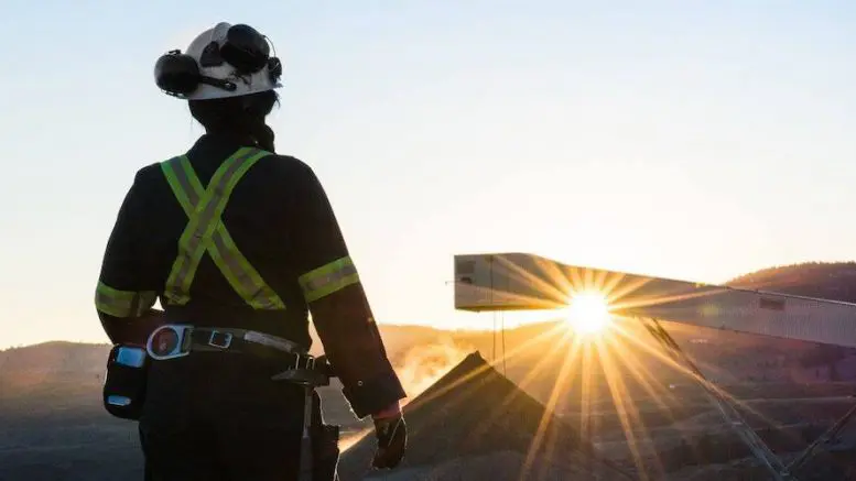 Geologist observing sunrise at site.